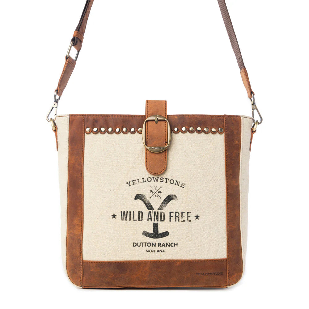 Yellowstone Lone Star Ivory Satchel Bag. Canvas and leather handbag with studded details and 'Yellowstone Wild and Free' branding on a white background.