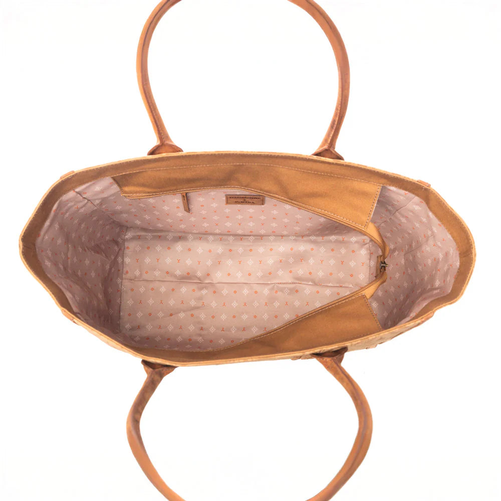 Yellowstone Bunkhouse Amber Weekender Bag. Brown leather tote bag with intricate patterns on a white background