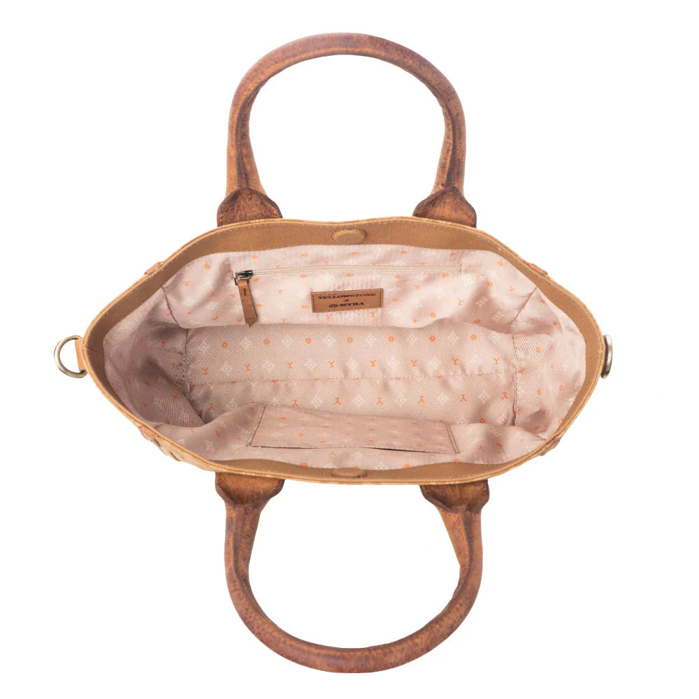 Yellowstone Wrangler’s Trail Crossbody with Pockets in Amber. Brown handbag with visible brand label on a white background