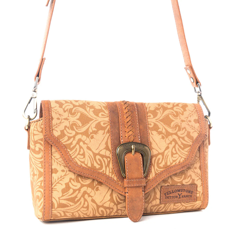 Yellowstone Maverick Sky Crossbody with Buckle in Amber. Brown patterned handbag with a decorative buckle on a white background