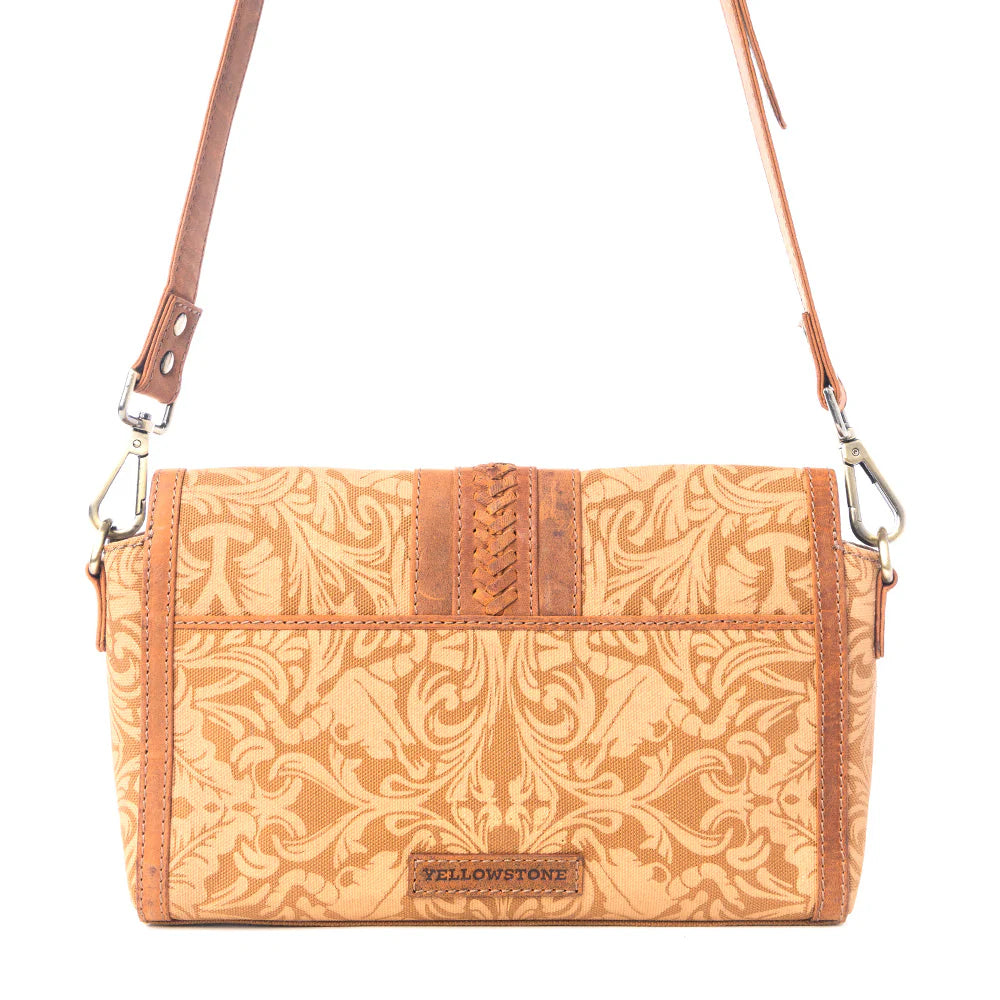 Yellowstone Maverick Sky Crossbody with Buckle in Amber. Brown patterned handbag with a decorative buckle on a white background