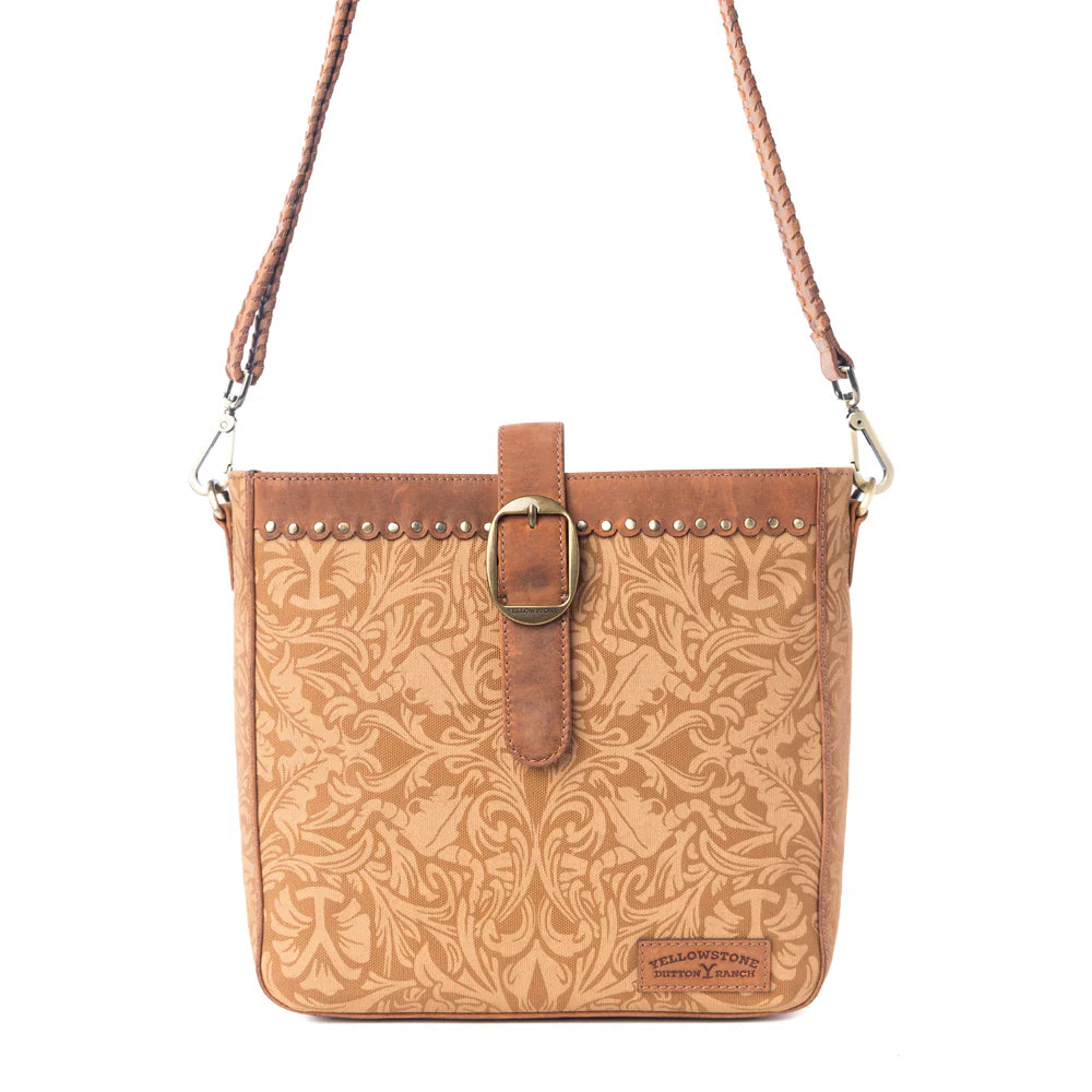 Yellowstone Montana Amber Buckle Sling Bag. Brown leather crossbody bag with floral pattern on a white background