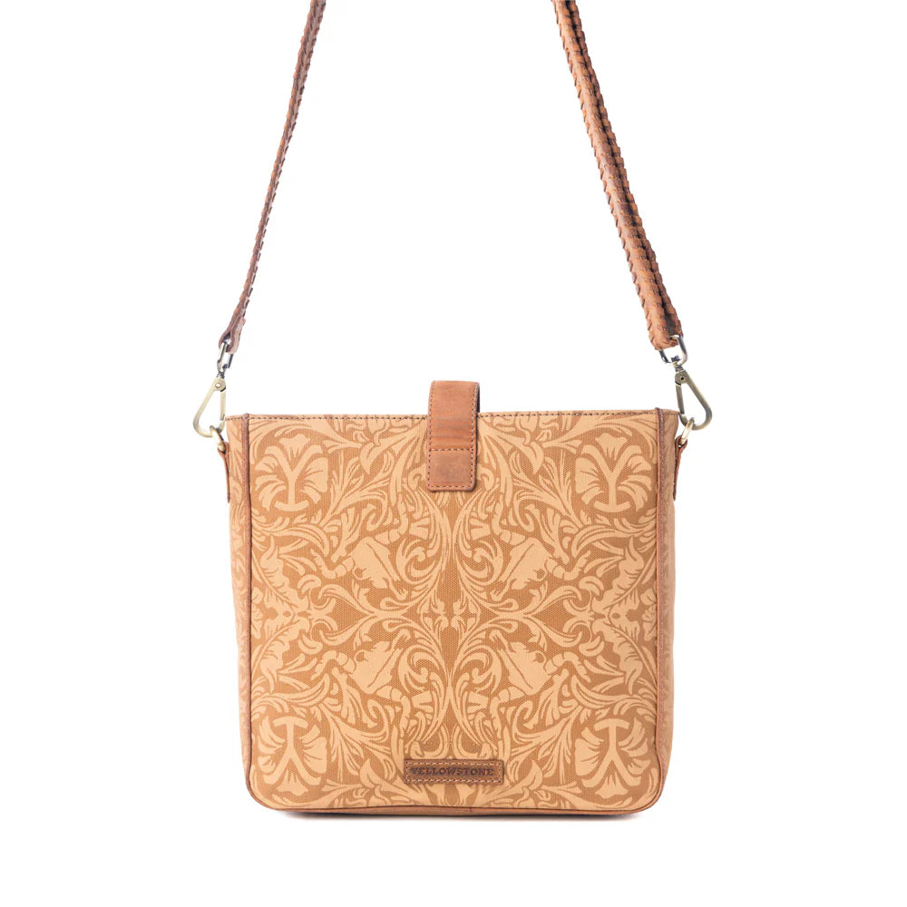 Yellowstone Montana Amber Buckle Sling Bag. Brown leather crossbody bag with floral pattern on a white background