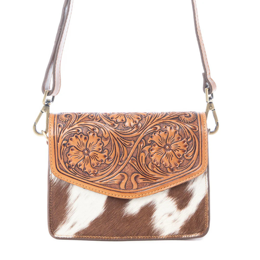 Bridle Blossom Handtooled Hairon Leather Bag in Amber Carve. Brown leather crossbody bag with cowhide pattern on a white background