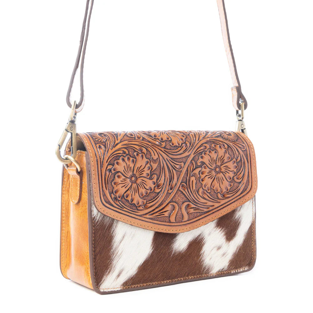Bridle Blossom Handtooled Hairon Leather Bag in Amber Carve. Brown leather and cowhide patterned handbag with floral embossing on a white background