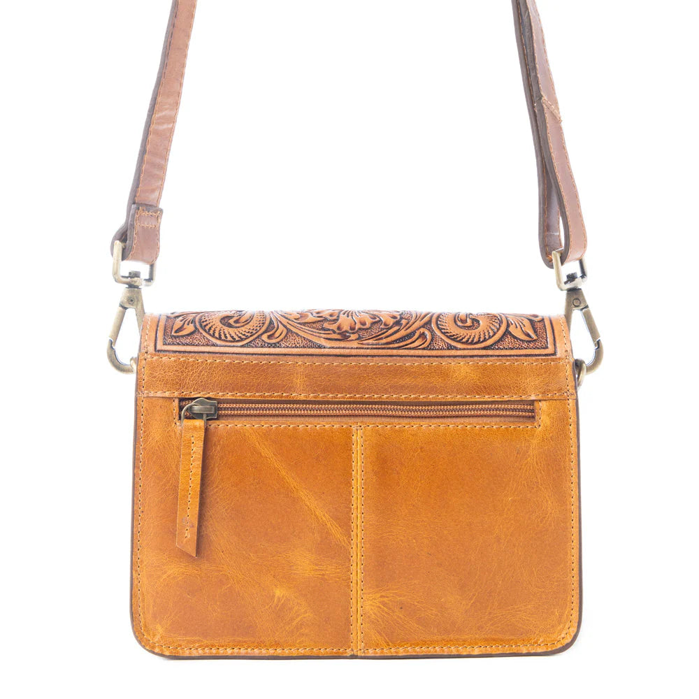 Bridle Blossom Handtooled Hairon Leather Bag in Amber Carve. Brown leather crossbody bag with intricate designs on a white background