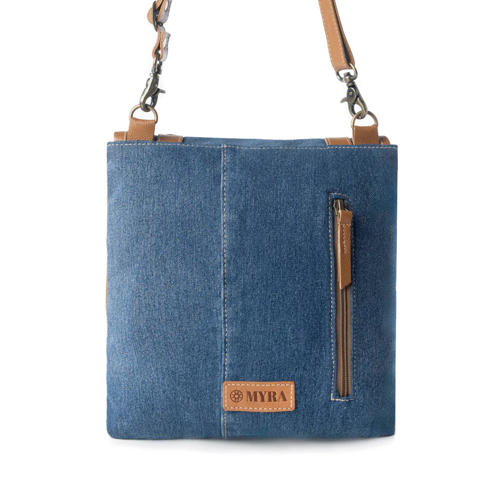 Blue denim crossbody bag with brown leather accents on a white background