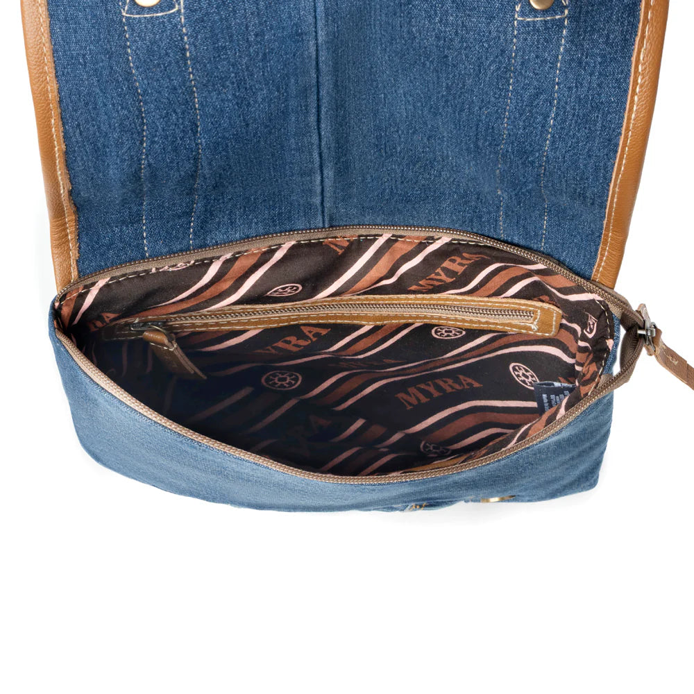 Blue denim handbag with a zebra pattern interior on a white background