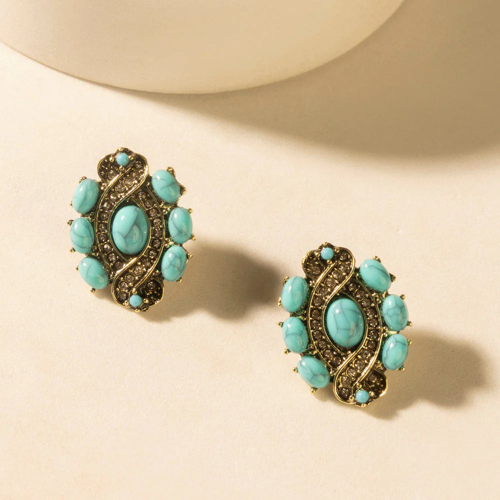 Pair of turquoise earrings on a beige background