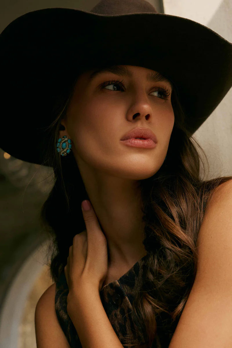 Woman wearing a large black hat with a blurred background