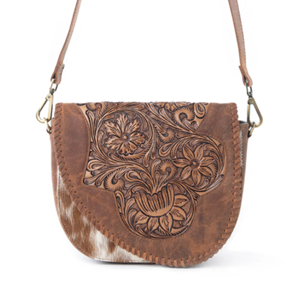 Brown leather handbag with intricate floral patterns on a white background