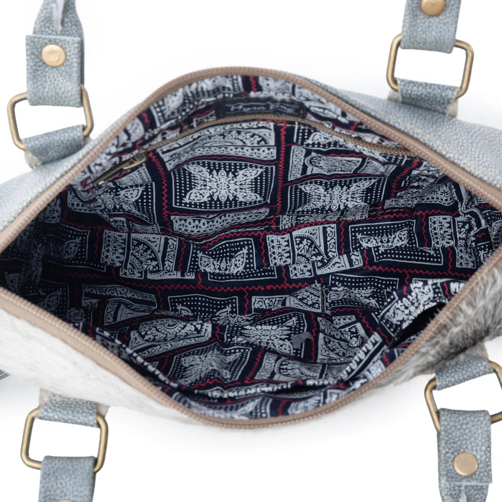 Close-up of a handbag with a patterned interior on a white background