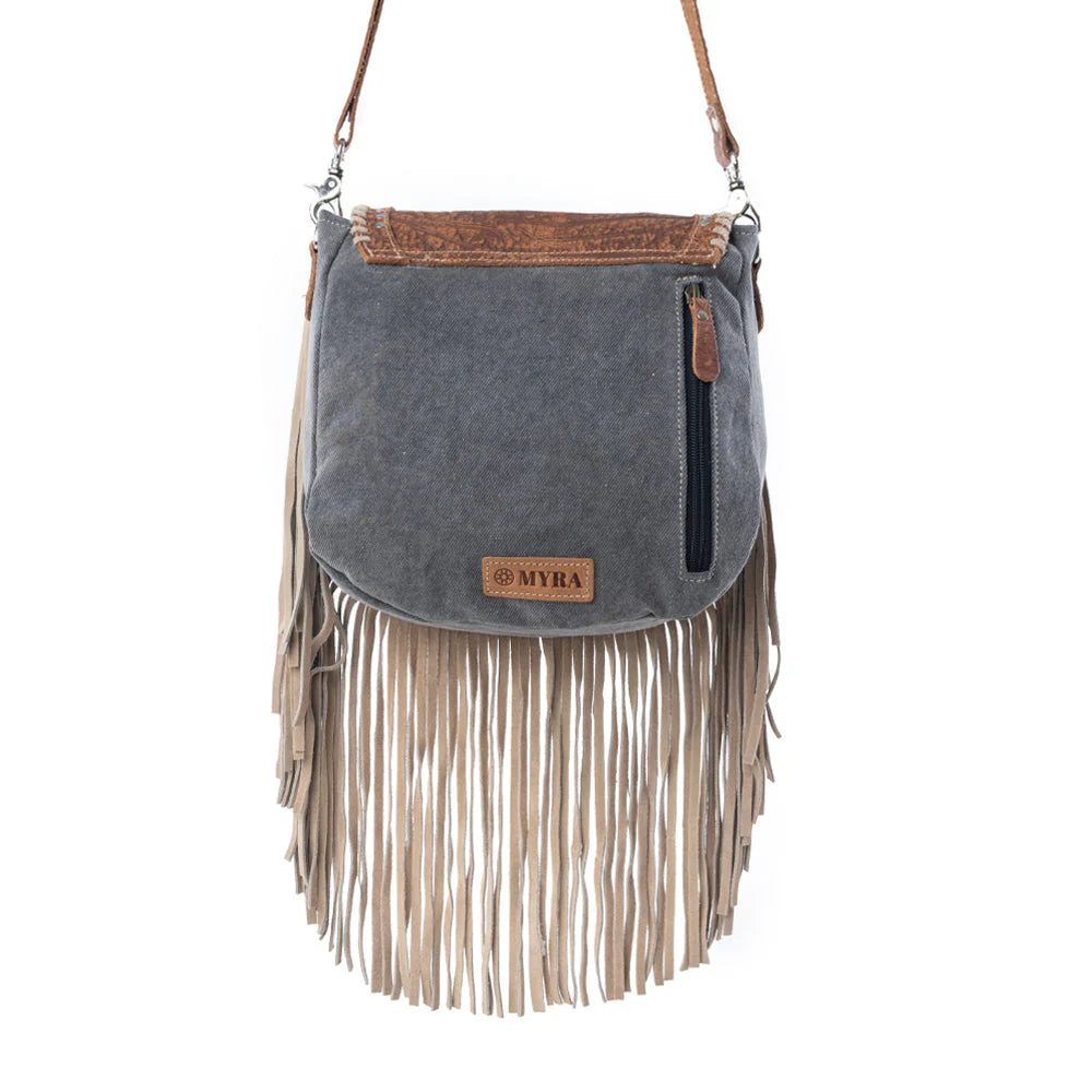 Gray suede handbag with fringes and brown accents on a white background