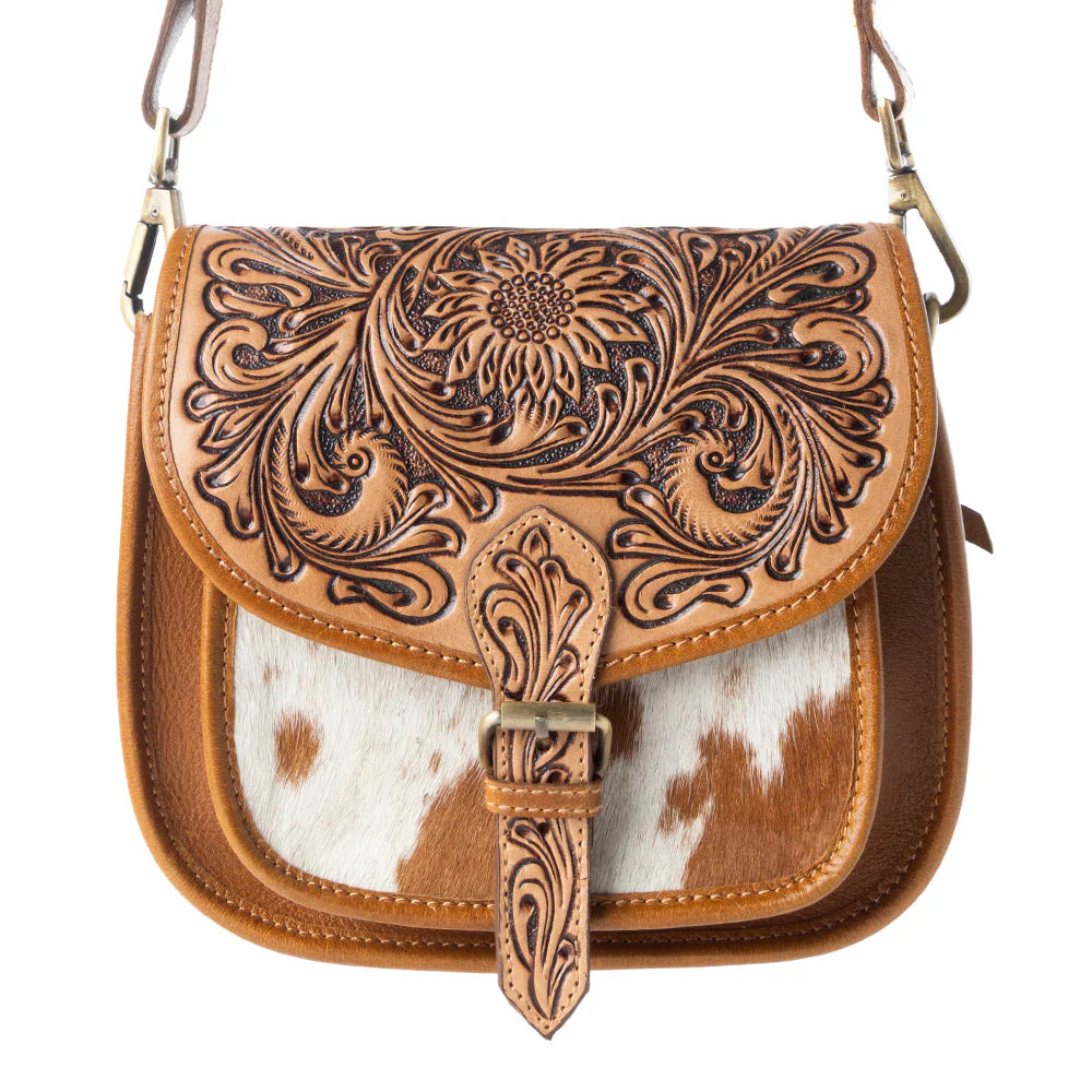 Brown leather handbag with intricate patterns and a cowhide design on a white background