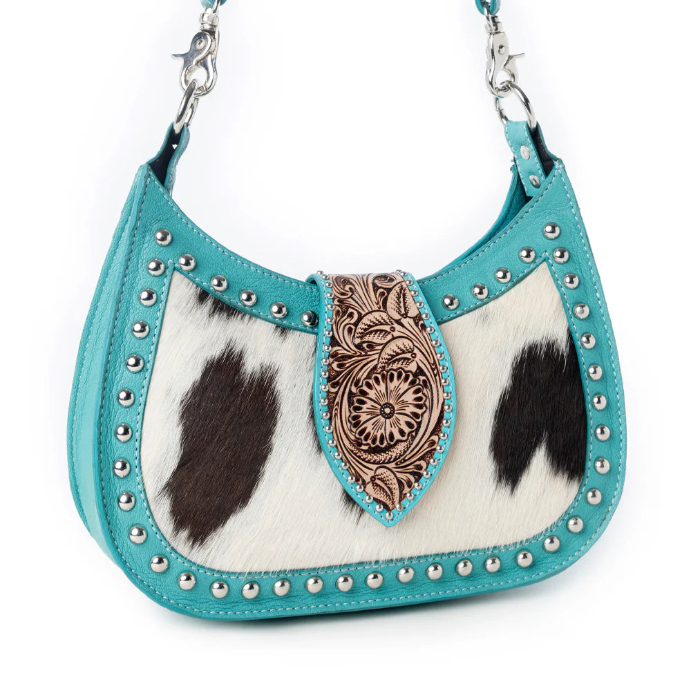 Turquoise handbag with cowhide pattern and decorative flap on a white background