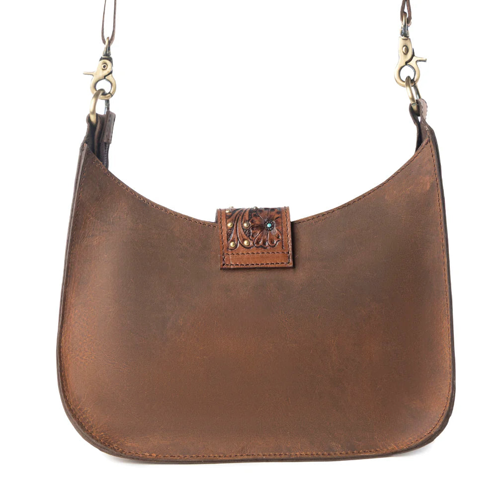 Brown leather handbag with decorative clasp on a white background