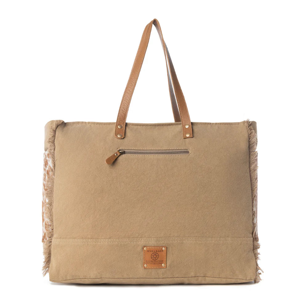 Beige tote bag with brown leather handle and fringes on a white background