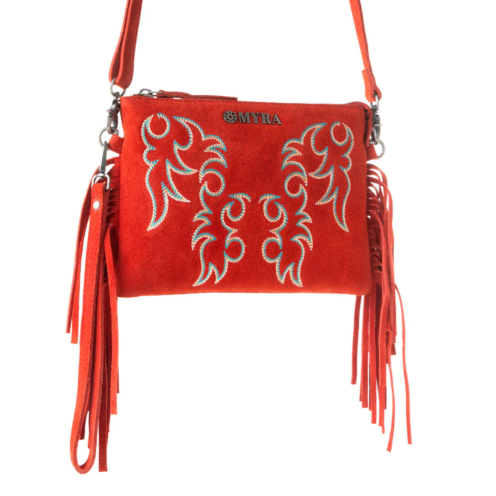 Red handbag with intricate designs and fringes on a white background