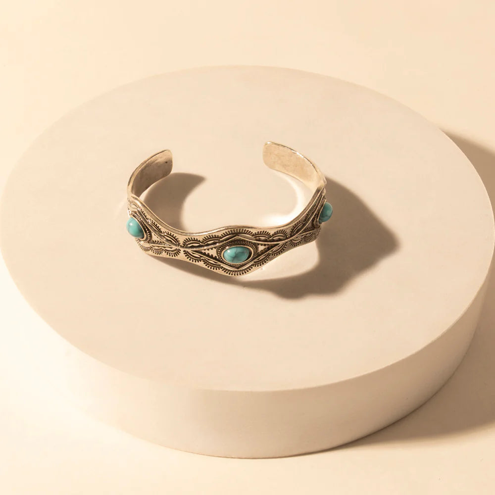 Decorative bracelet with turquoise stones on a beige background