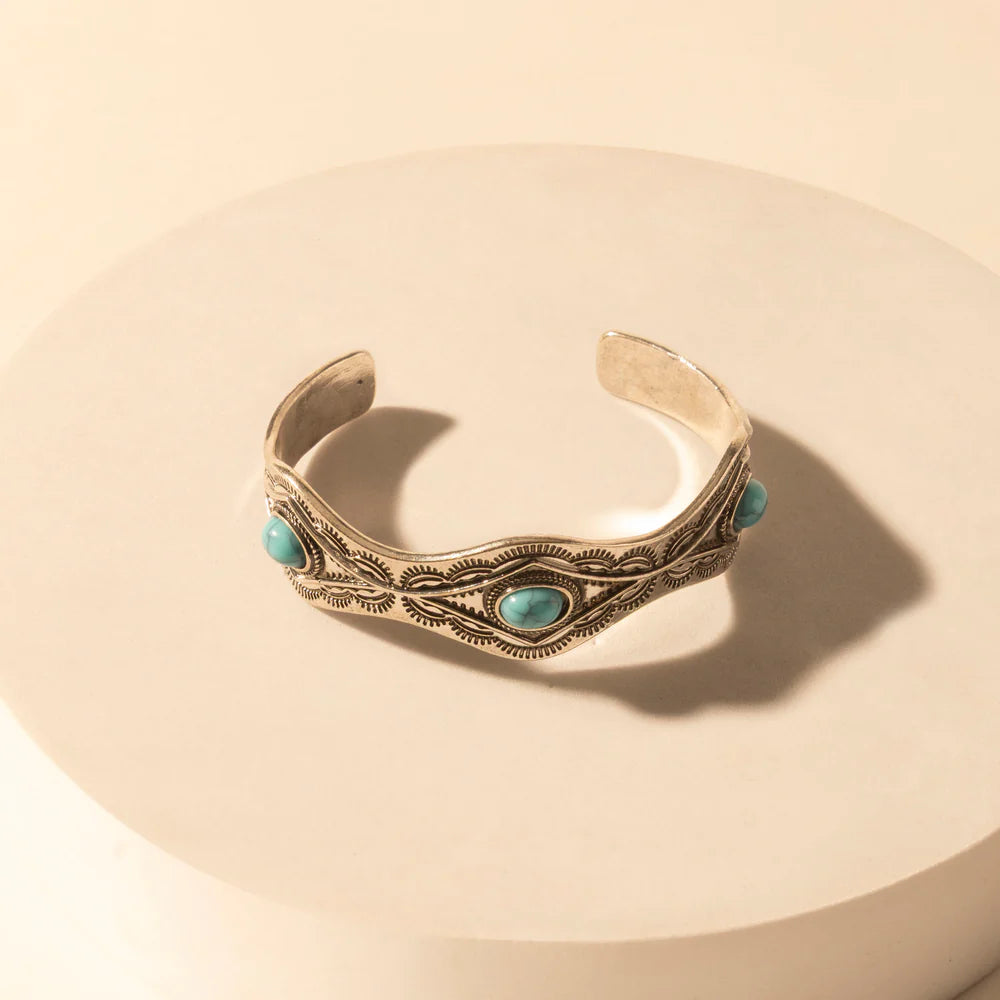 Decorative bracelet with turquoise stones on a beige background