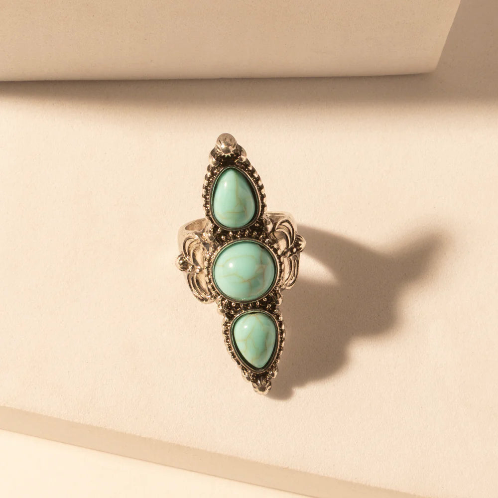 Ring with turquoise stones on a beige background