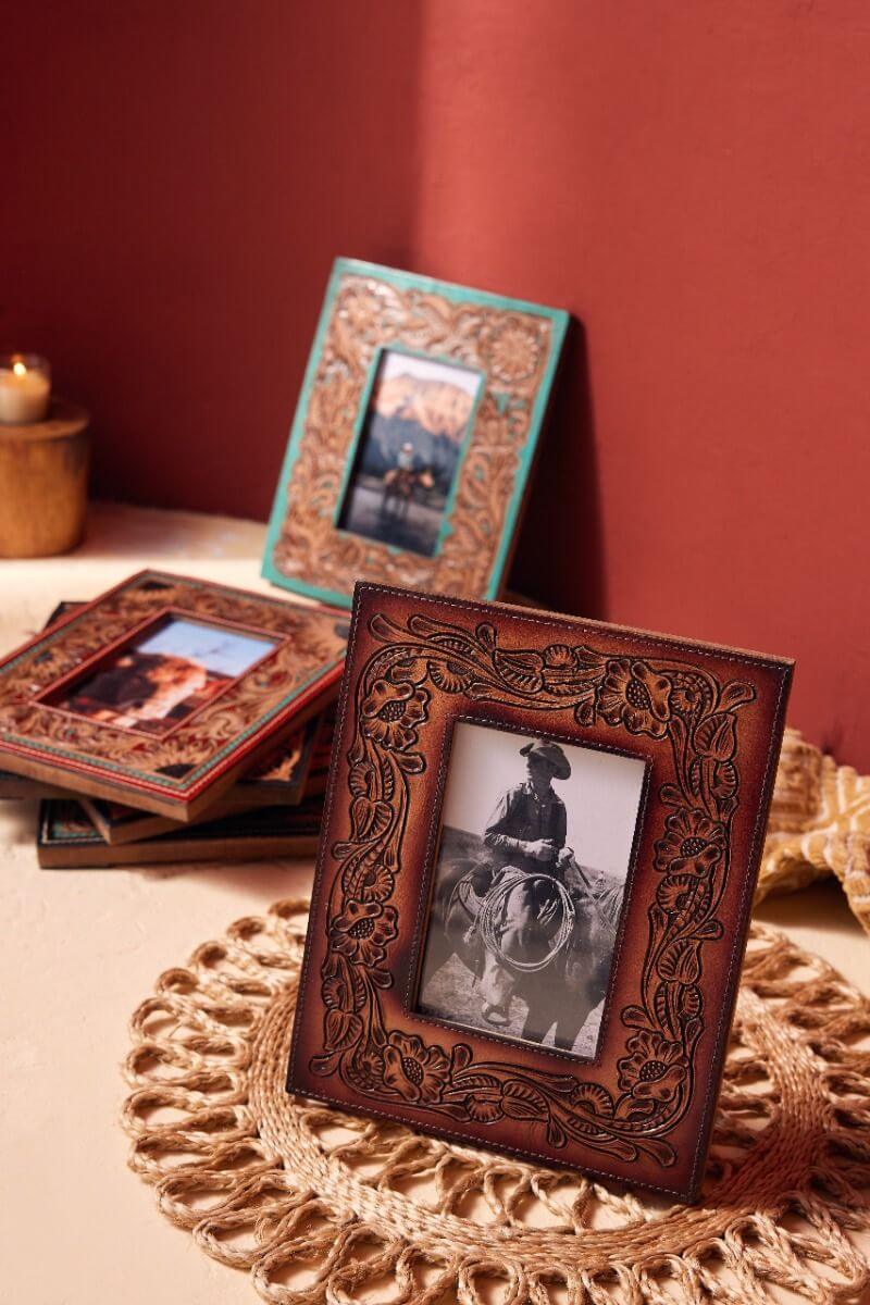 Time of Traditions Hand-Tooled Photo Frame. Decorative picture frames on a textured surface with a red background.