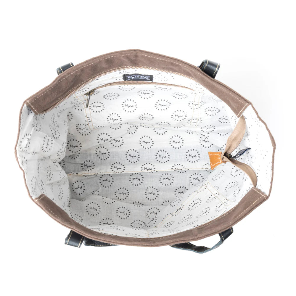 Brown leather bag with floral patterned interior on a white background