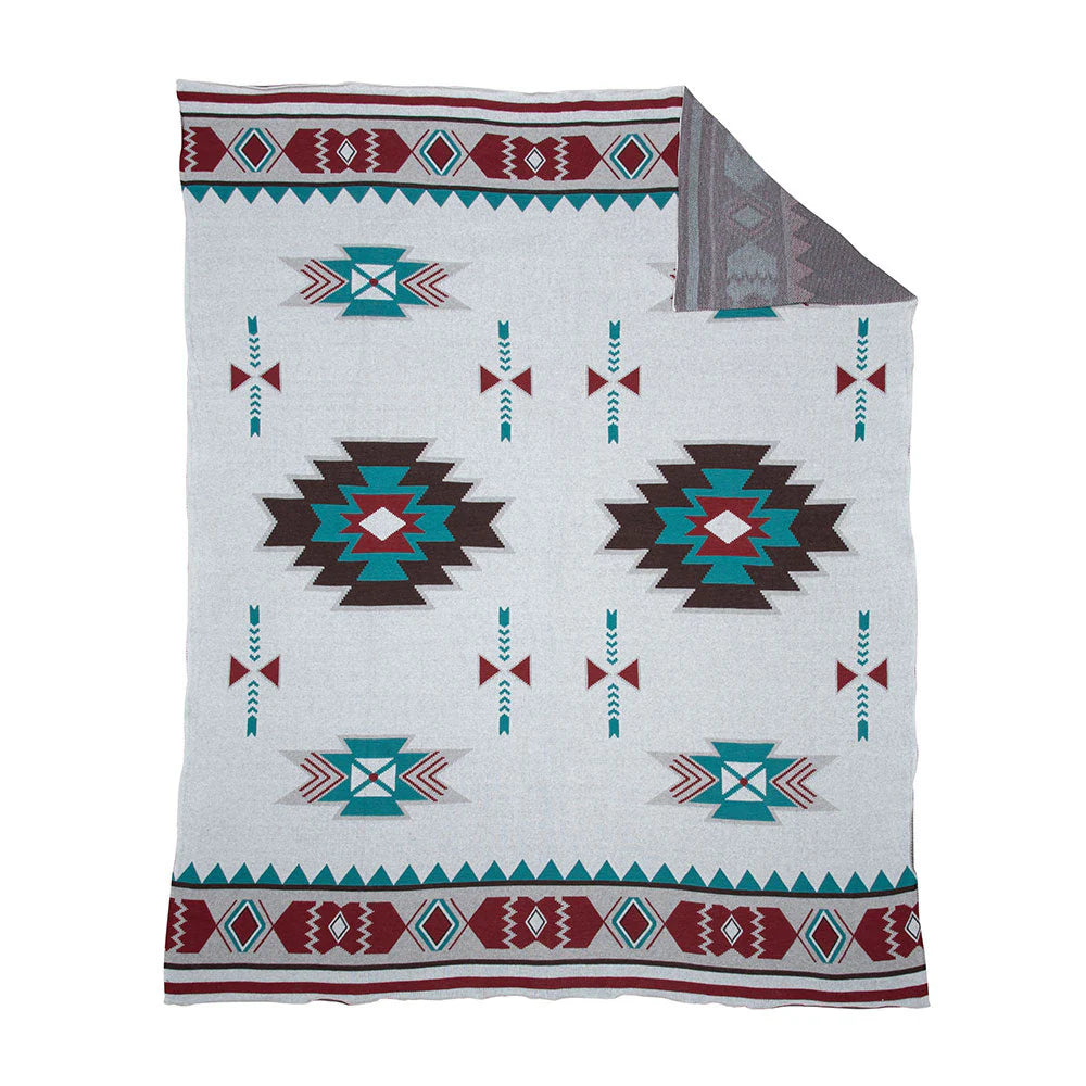 Canyon View Woven Throw. A woven throw with a geometric tribal design in Southwest colors, featuring a mix of geometric patterns and a mix of white, red, and blue colors.