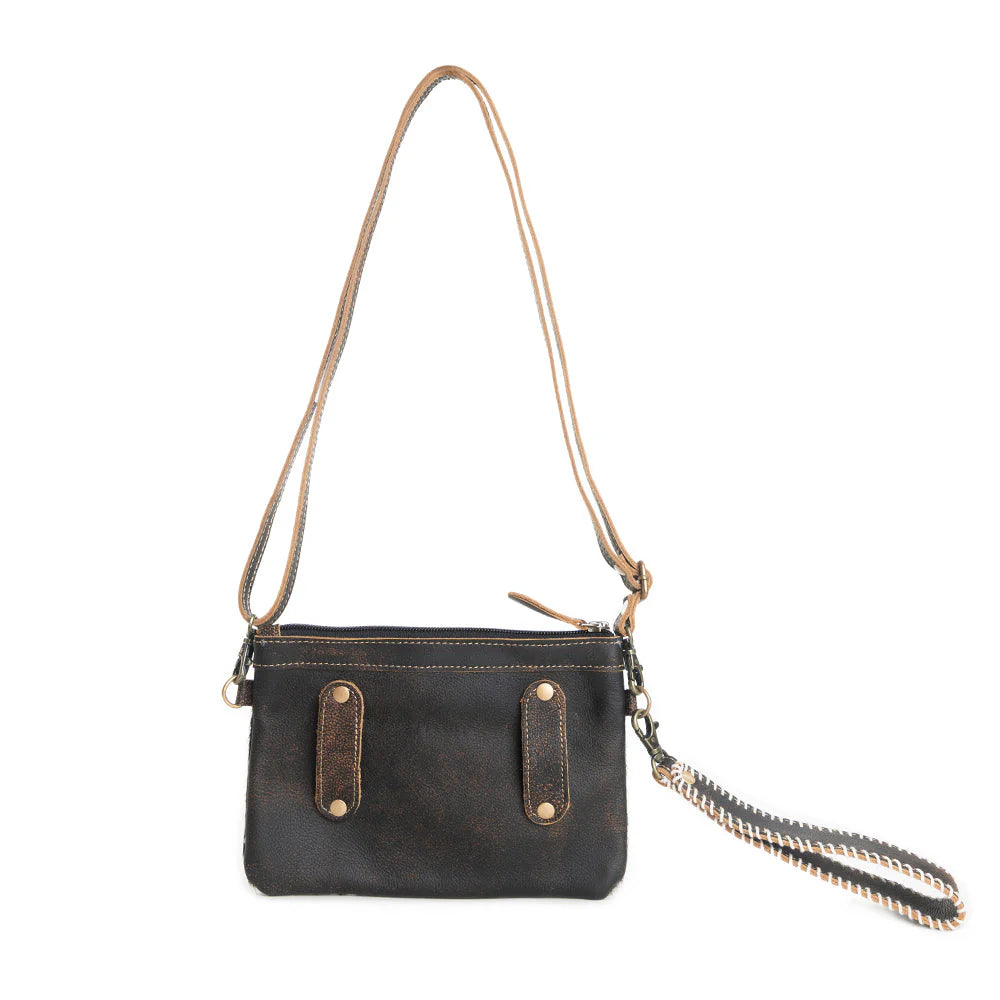Eye of the Goddess Crossbody Bag in Black. Black leather handbag with gold accents on a white background