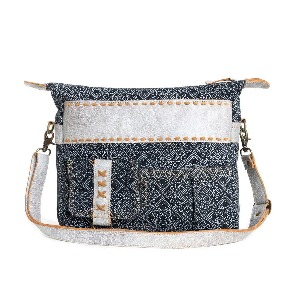 Women's Moroccan Nights Shoulder Bag. A shoulder bag with a geometric pattern, predominantly in black and white, with leather accents and artisanal stitching. It includes an adjustable shoulder strap and multiple pockets.