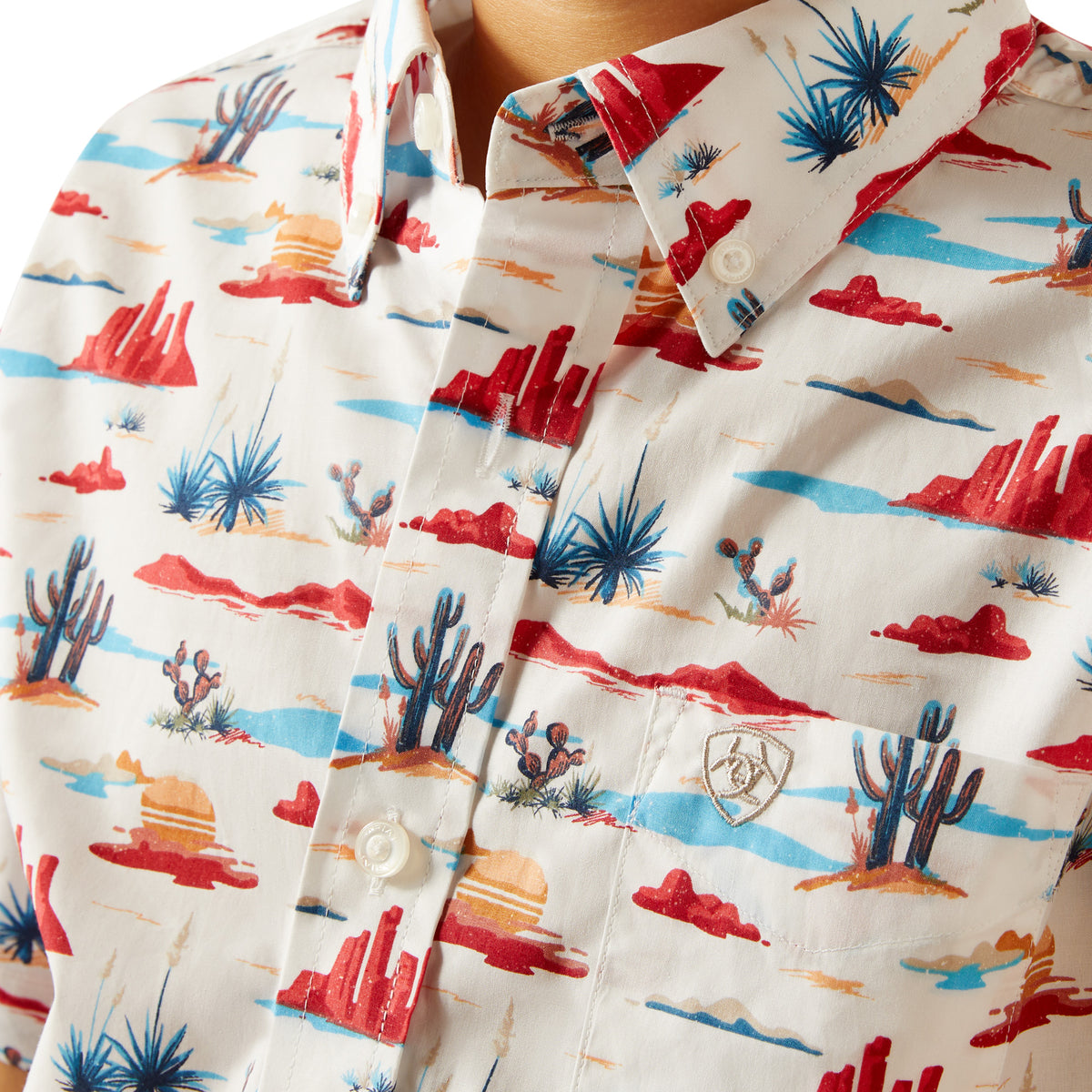 Ariat Boy's Scout S/S Western Shirt. Close-up of a shirt with a colorful desert pattern on a white background
