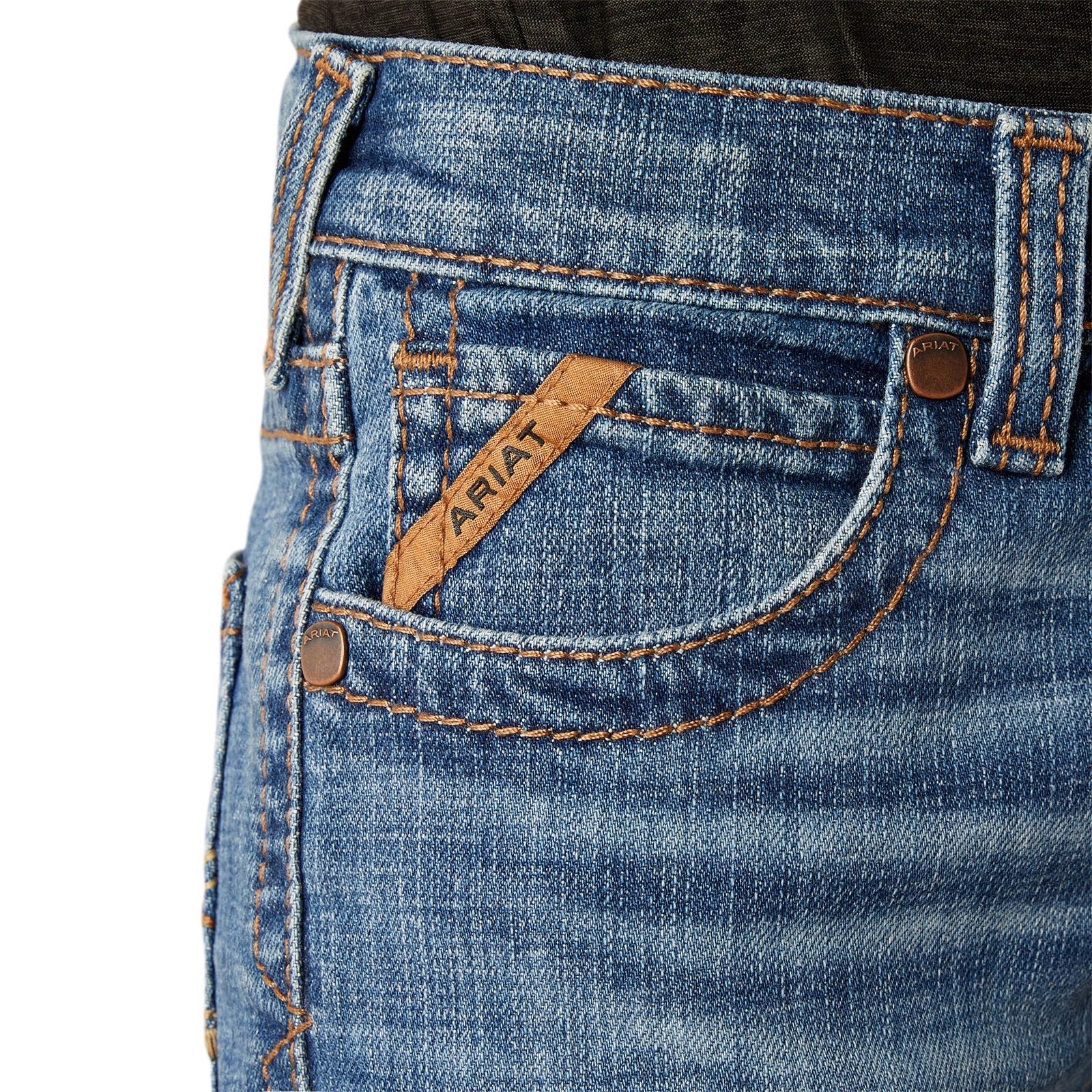 Ariat Boy's B5 Norwich Slim Fit Jean. Close-up of blue jeans with a brand label on a white background