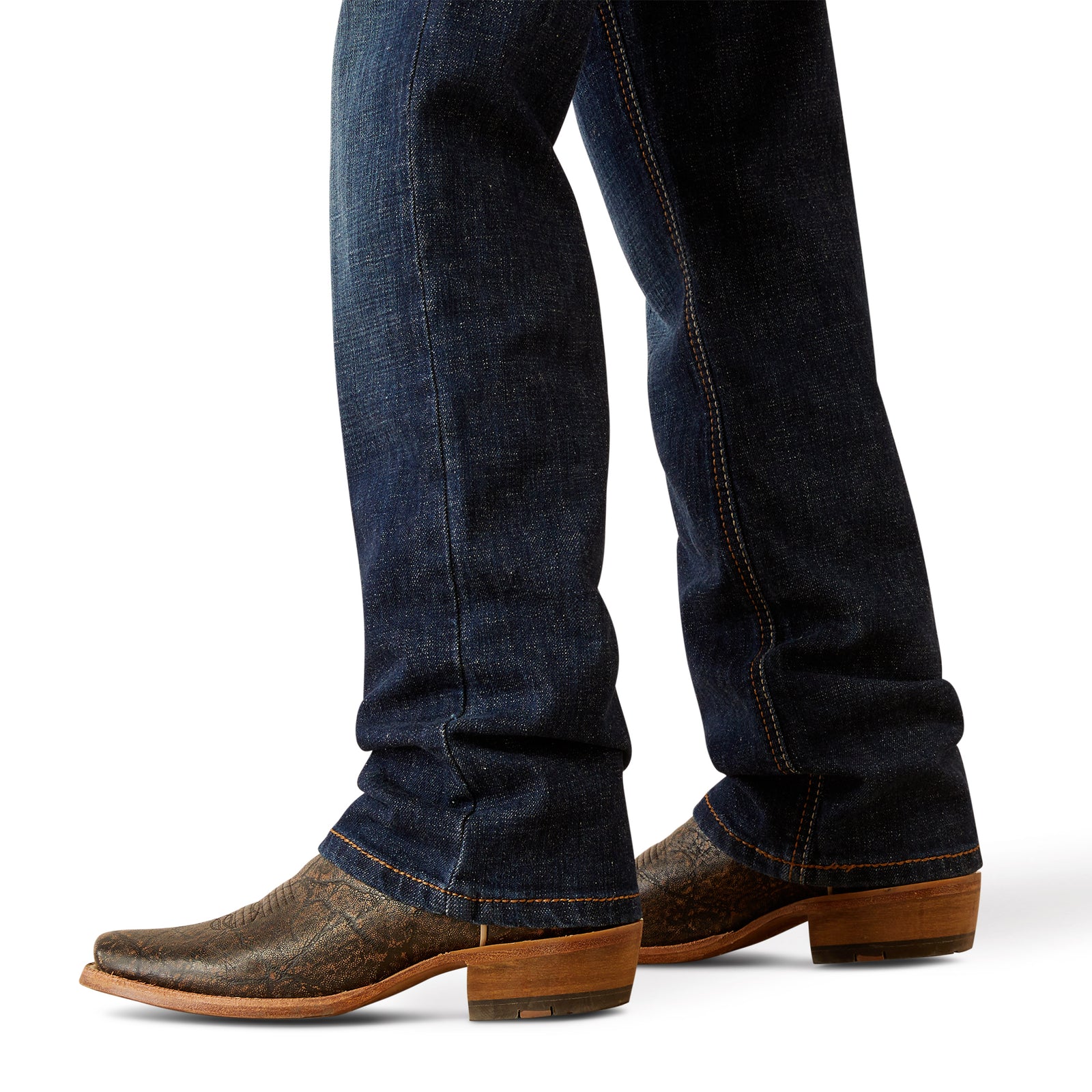 Ariat Boy's B4 Rolland Relaxed Fit Jean. Close-up of blue jeans and brown cowboy boots on a white background