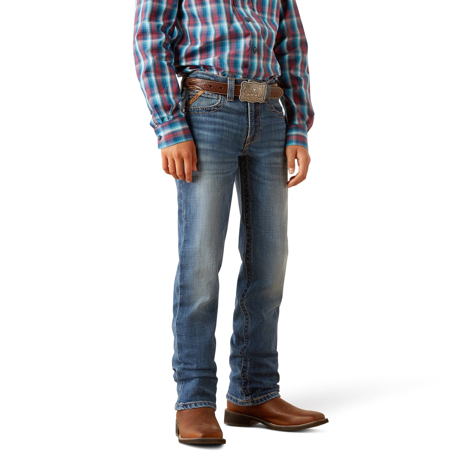 Ariat Boy's B5 Slim Bennet Straight Leg Jean. Person wearing blue jeans and a plaid shirt on a white background