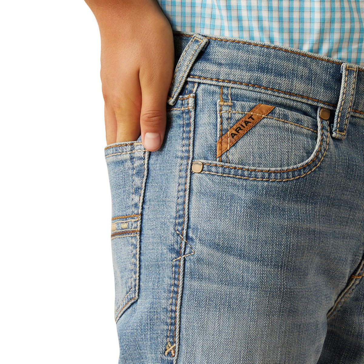 Close-up of blue jeans with a brand label on a white background