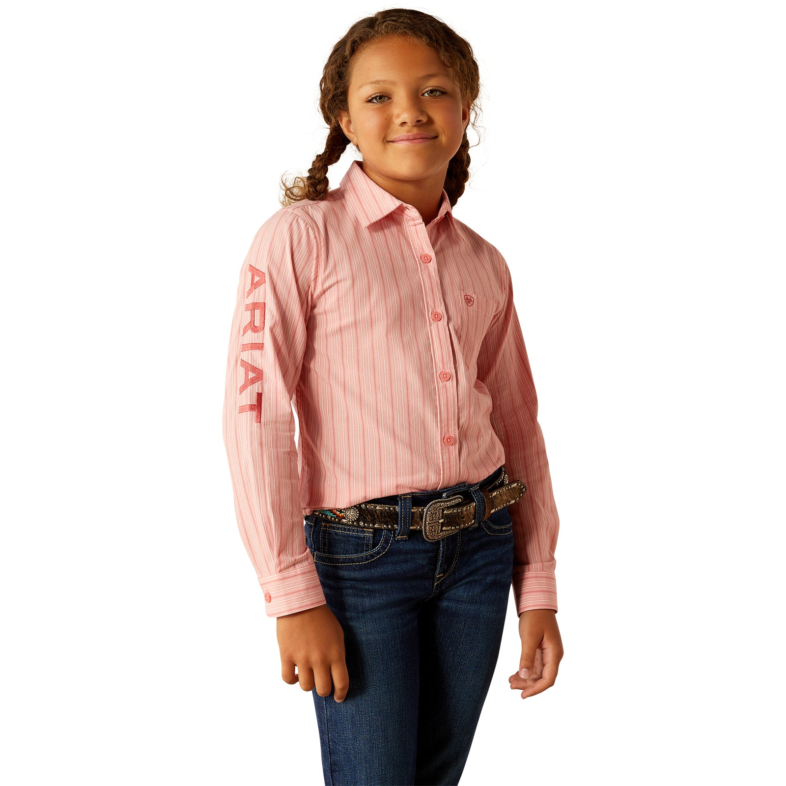 Ariat Girl's Team Kirby L/S Western Shirt. Young girl wearing a pink striped shirt with 'Ariat' branding on a white background
