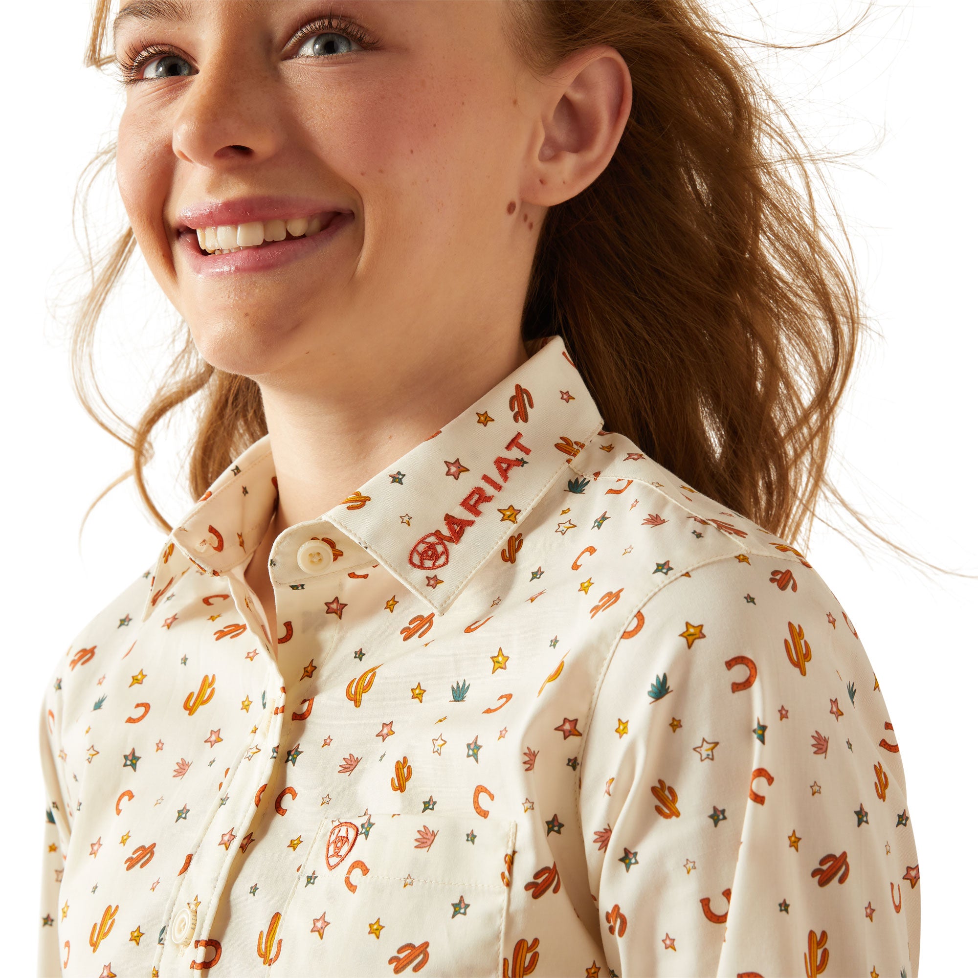 Ariat Girl's Team Kirby L/S Western Shirt. Young girl wearing a floral blouse and jeans on a white background