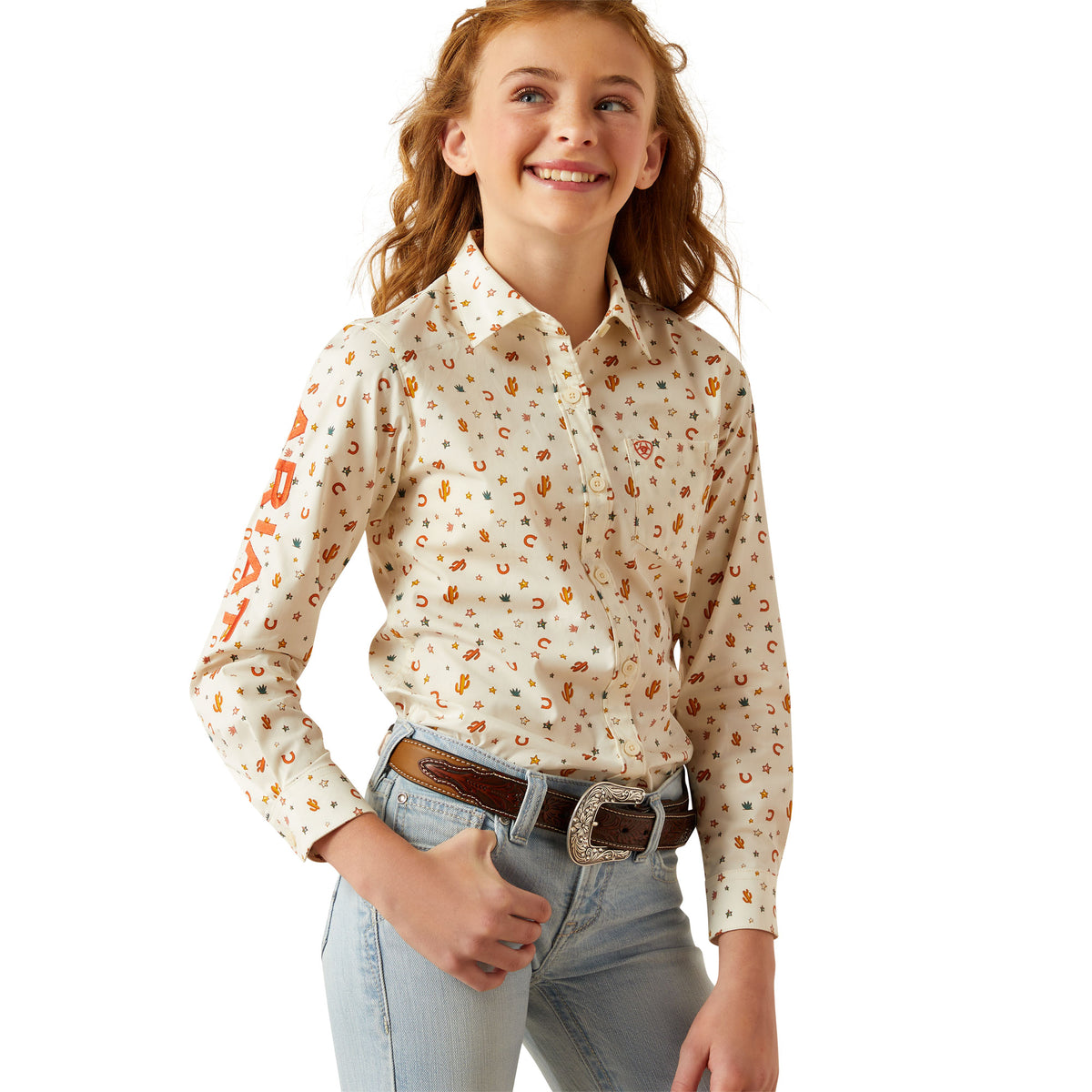 Ariat Girl&#39;s Team Kirby L/S Western Shirt. Young girl wearing a floral blouse and jeans on a white background
