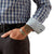Ariat Men's Wrinkle Free Bronson Fitted L/S Western Shirt. Person wearing a blue and white checkered shirt with rolled-up sleeves, showing tattoos and jewelry.