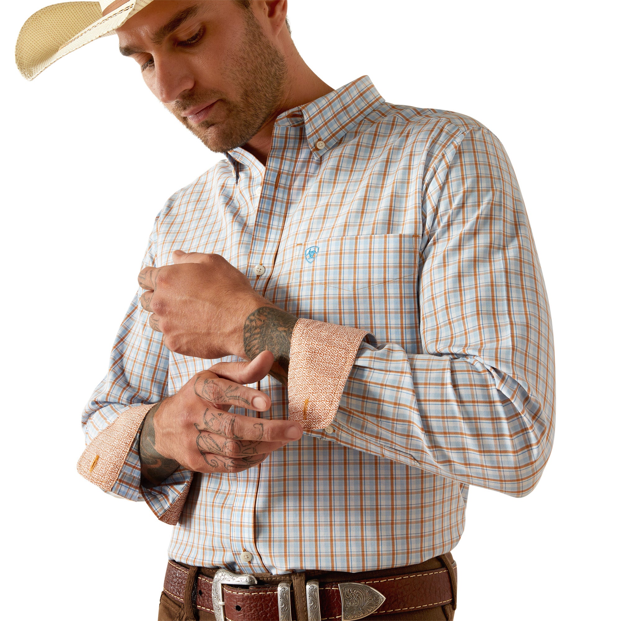 Ariat Men's Wrinkle Free Brendan Fitted L/S Western Shirt. Man wearing a plaid shirt with rolled-up sleeves, holding a bandage on his arm.