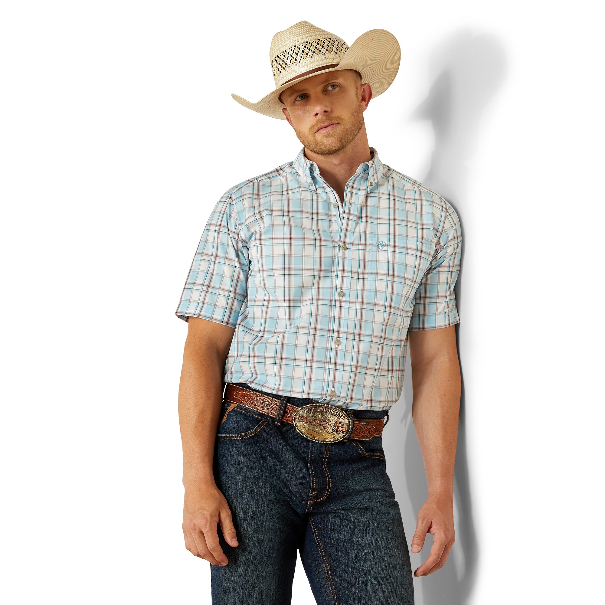 Ariat Men's Pro Series Geoffery Classic Fit S/S Western Shirt. Man wearing a plaid shirt, jeans, and a cowboy hat against a white background