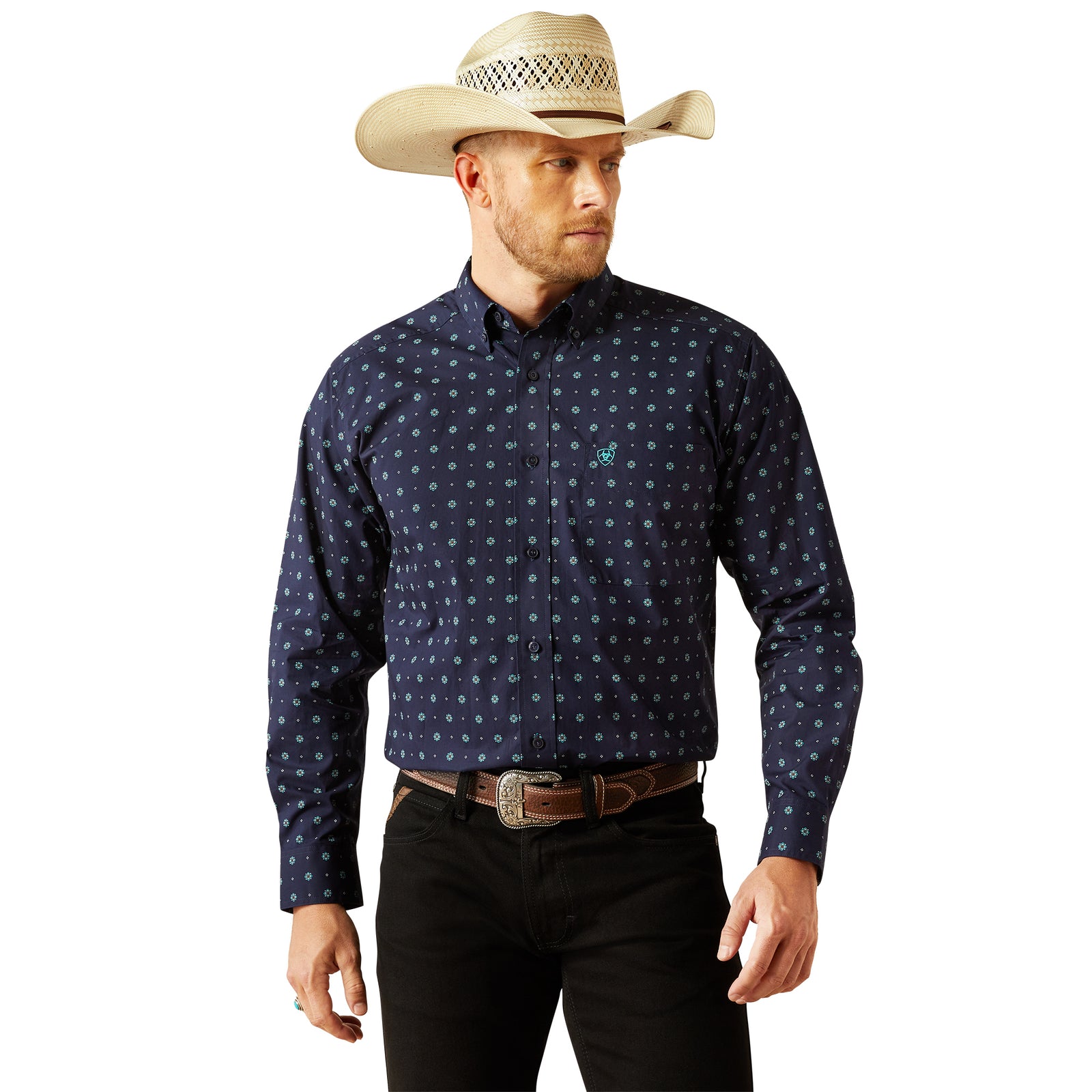 Ariat Men's Jacobi Classic Fit L/S Western Shirt. Man wearing a navy patterned shirt, black pants, and a beige cowboy hat on a white background
