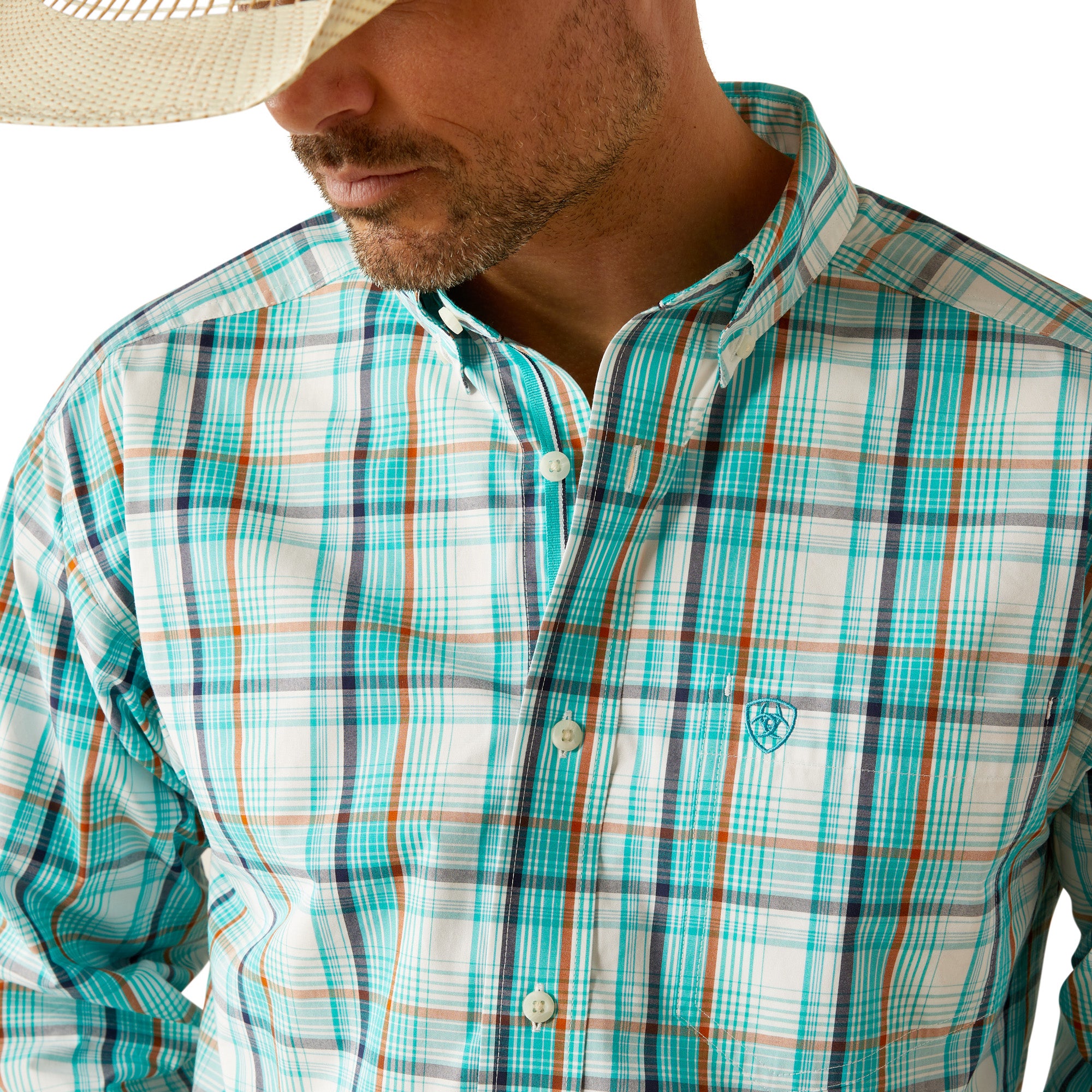 Ariat Men's Pro Series Justice Classic Fit L/S Shirt. Man wearing a plaid shirt, jeans, and a cowboy hat on a white background