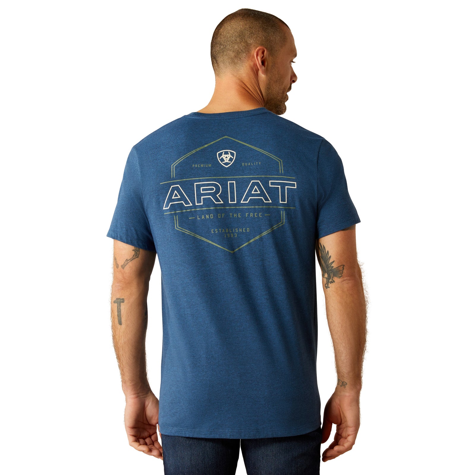 Ariat Men's Line Frame Hex T-Shirt. A man wearing a blue Ariat crew neck t-shirt with a geometric hexagon design containing the brand name 'ARIAT' and some graphics.