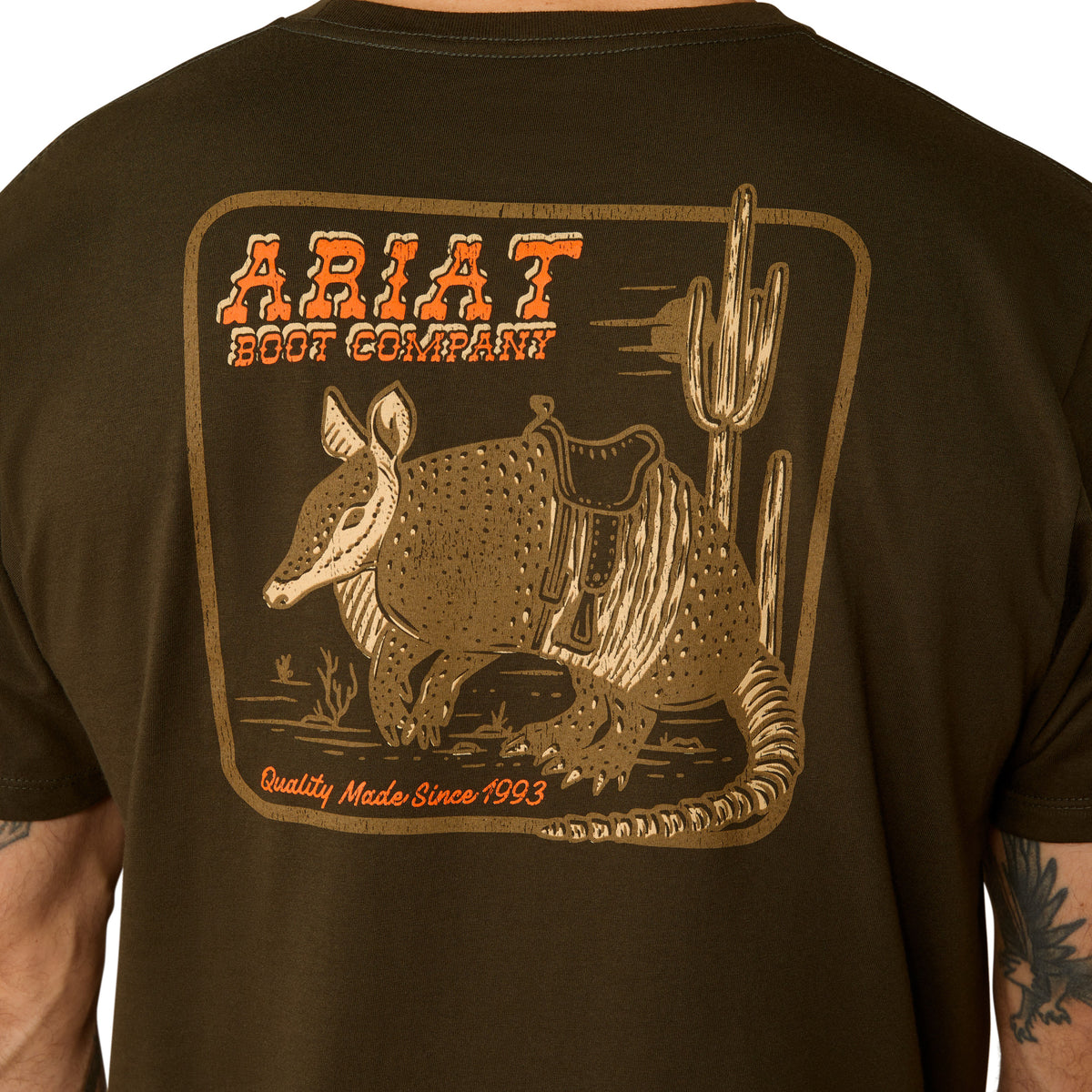 Ariat Men's Armadillo on a Half Shell T-Shirt. Brown t-shirt with armadillo and cactus graphic on the back.