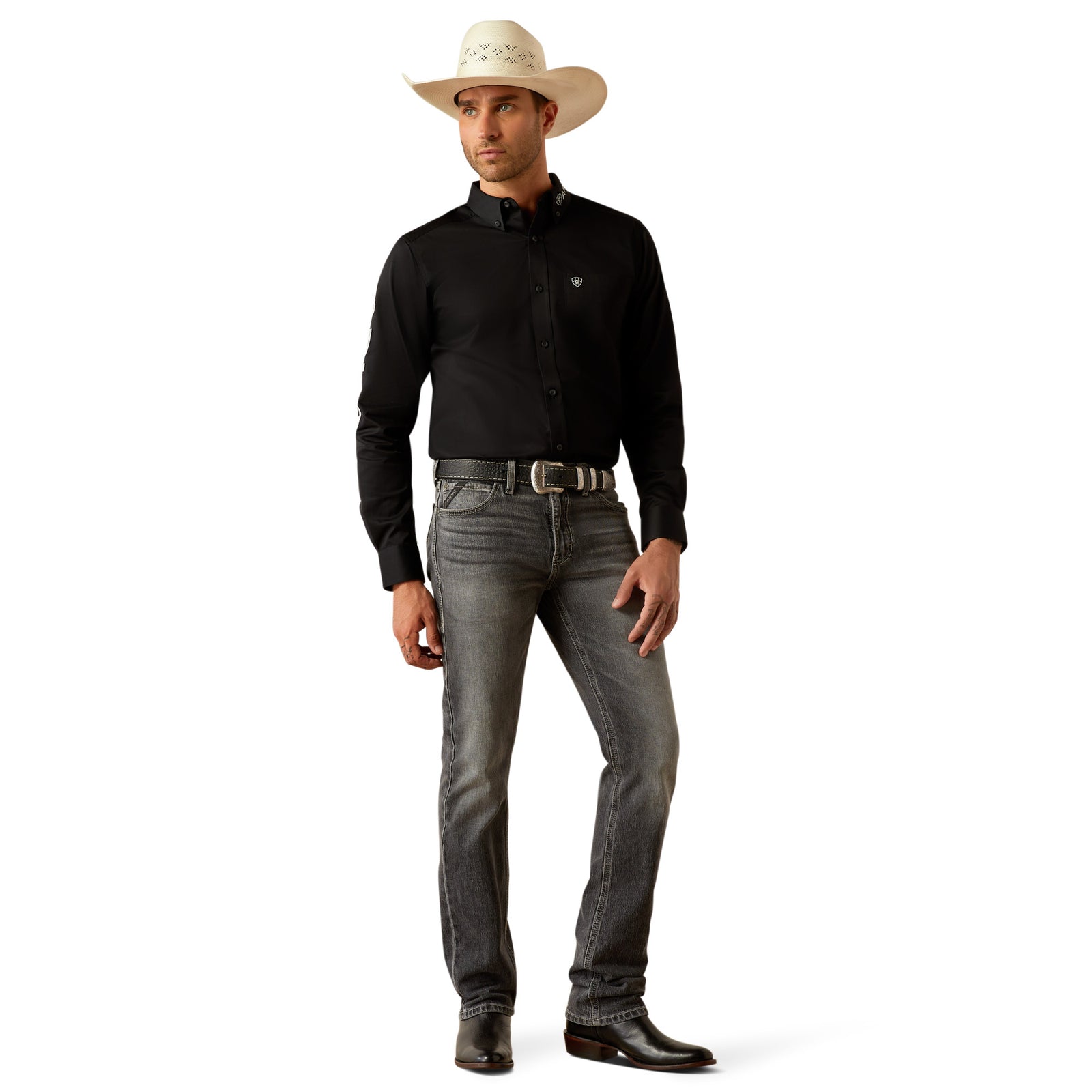 Ariat Men's Team Logo Twill L/S Western Shirt. Man wearing a black shirt, gray jeans, and a white cowboy hat on a white background