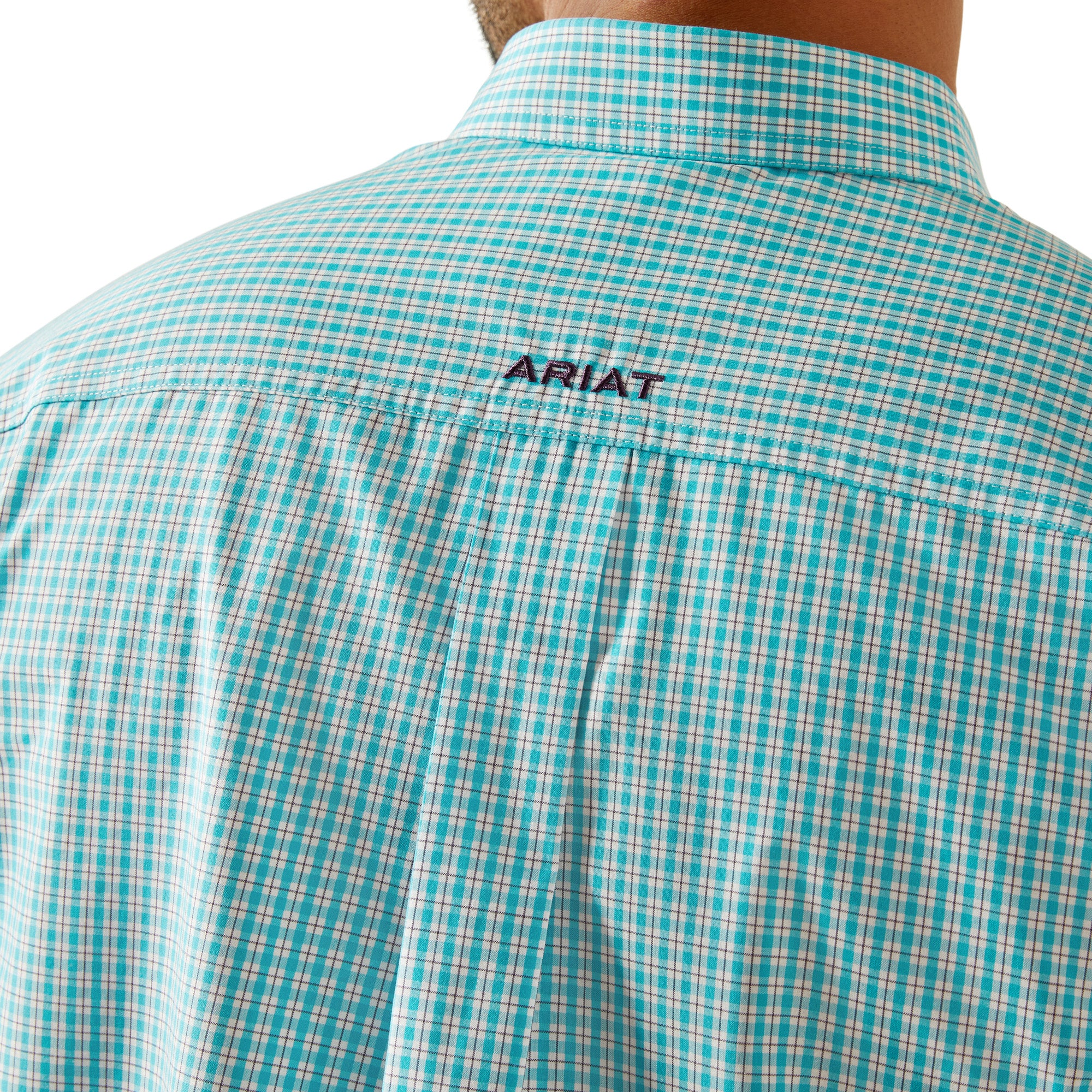 Ariat Men's Pro Series Wilmer L/S Western Shirt. Man wearing a light blue checkered shirt, dark jeans, and a straw cowboy hat on a white background