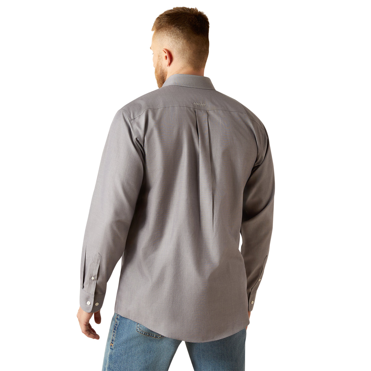 Ariat Men's Wrinkle Free Solid L/S Western Shirt. Man wearing a gray shirt and blue jeans on a white background