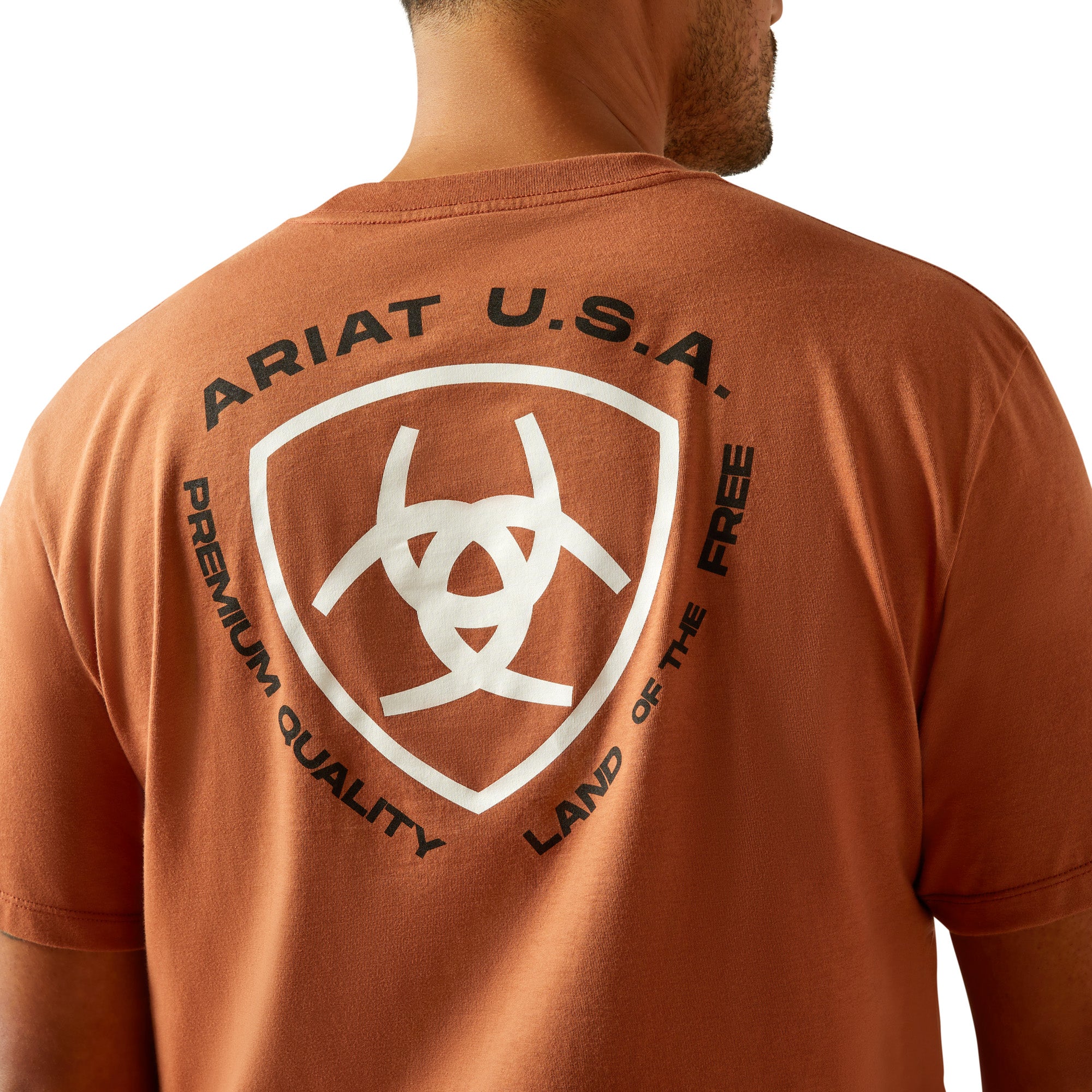 Ariat Men's Loft Simple Seal T-Shirt. Man wearing a brown t-shirt with a logo on a white background