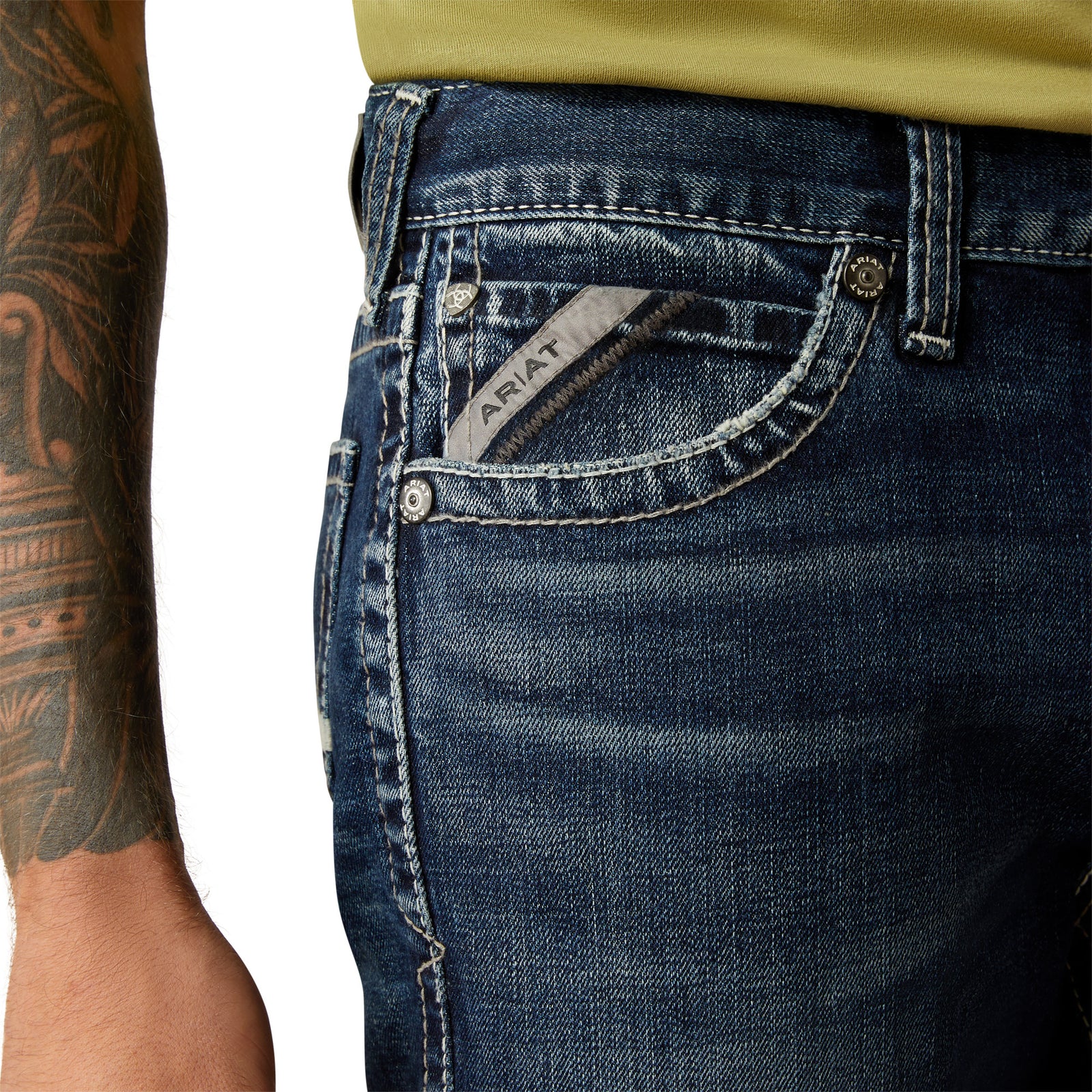 Ariat Men's M8 Modern Matthew Straight Leg Jean. Close-up of blue jeans with a visible Ariat logo on a white background